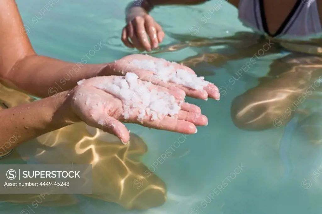 Young girl in the Dead Sea holding sea salt in her hands, En Bokek, Israel, Middle East