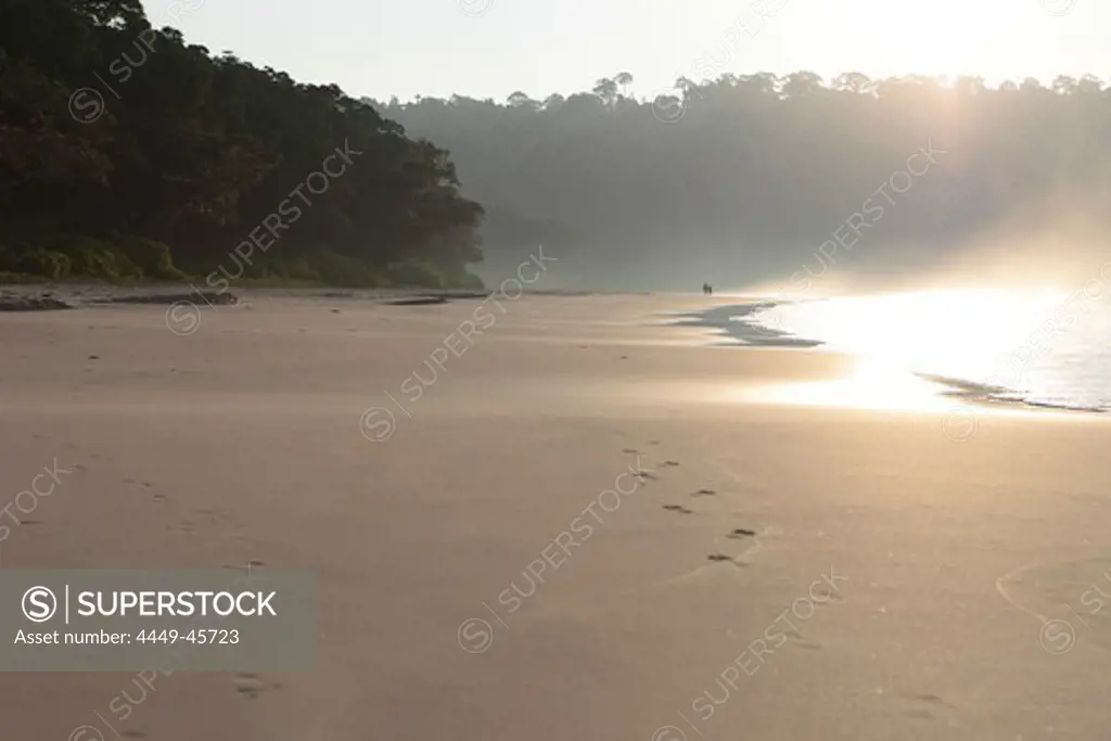 Couple walking along Radha Nagar Beach at sunrise, Beach 7, Havelock Island, Andamans, India