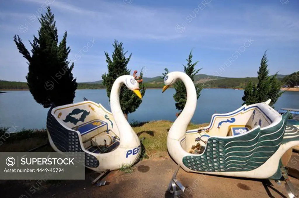 Two swan boats on the lake shore near Da Lat in the southern mountains, Vietnam