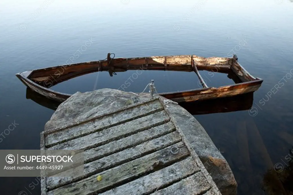 Half sunken wooden rowing boat at a jetty, island of Norrbyskaer, Vaesterbotten, Sweden, Europe