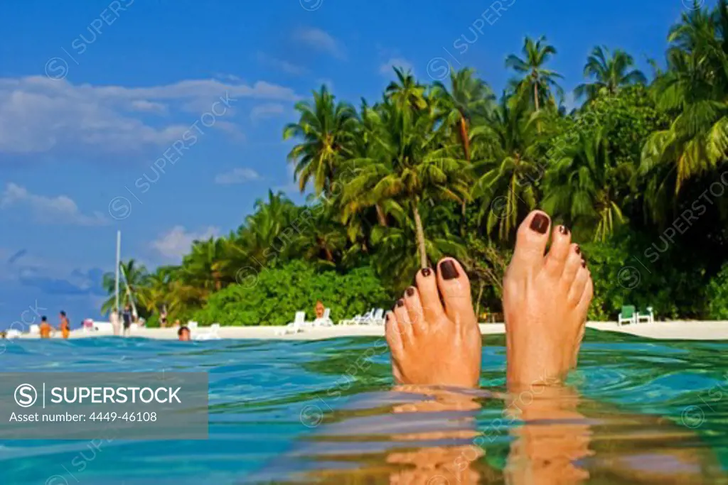 Womens feet, Palm trees at the beach of Biyadhoo Island, Indian Ocean, South Male Atoll, Maldives