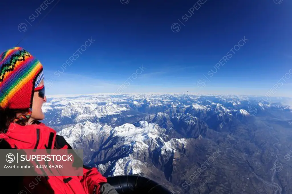Woman in hot-air balloon enjoying view to Dolomites and valley of Piave, aerial photo, Belluno, Dolomites, Venetia, Italy, Europe
