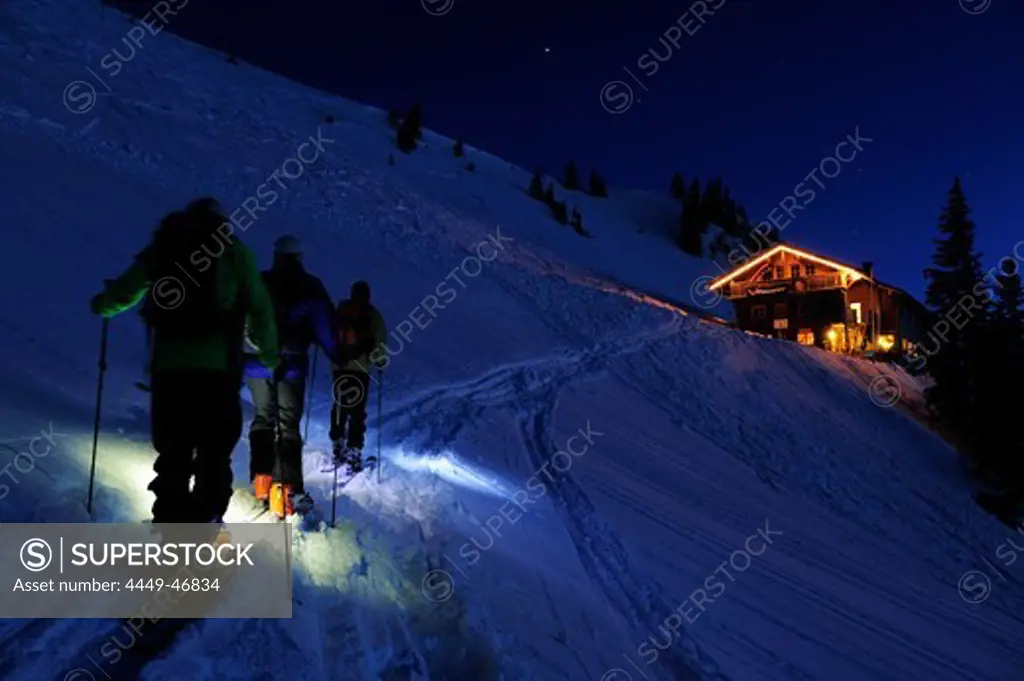 Three men backcountry skiing at night reaching hut Staufner Haus, Hochgrat, Nagelfluh range, Allgaeuer Alpen range, Allgaeu, Bavaria, Germany
