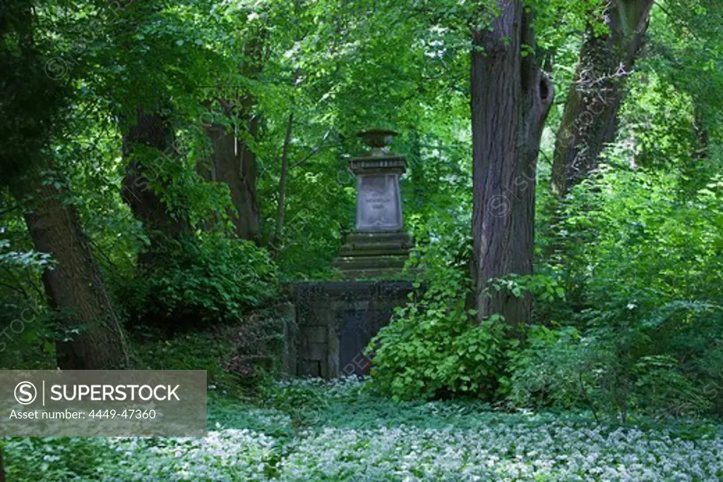 Gravestone amongst old trees in Wrisberg Garden, Wrisbergholzen. Lower Saxony, Germany