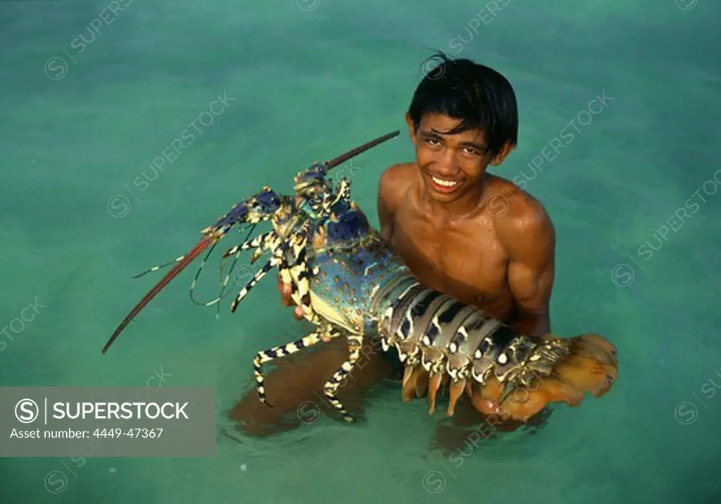 Boy in the water holding giant pacific lobster, Cebu Island, Visayas, Philippines, Asia