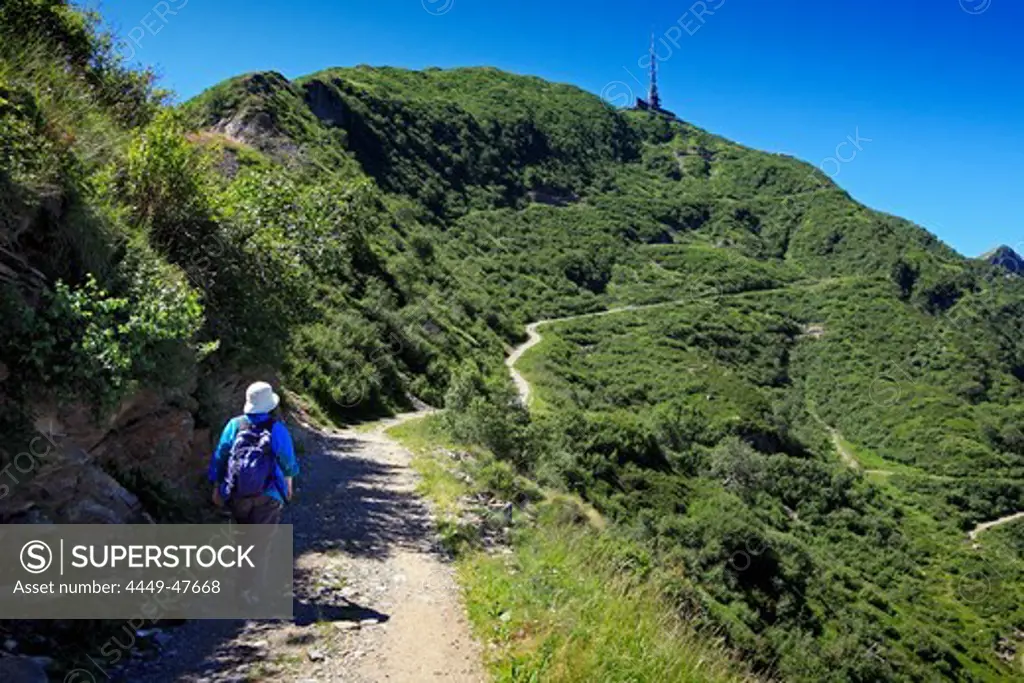 Woman hiking in the mountains to Monte Tamaro, Ticino, Switzerland