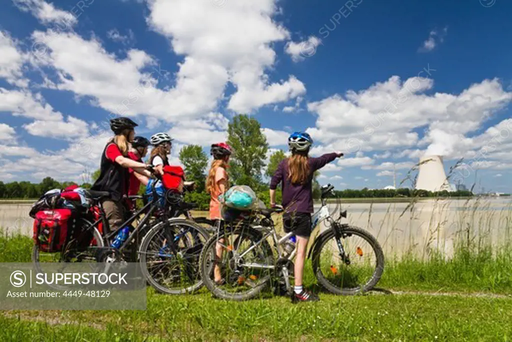 Cyclists looking over river Isar to Isar 1 Nuclear Power Plant, near Landshut, Isar Cycle Route, Lower Bavaria, Germany