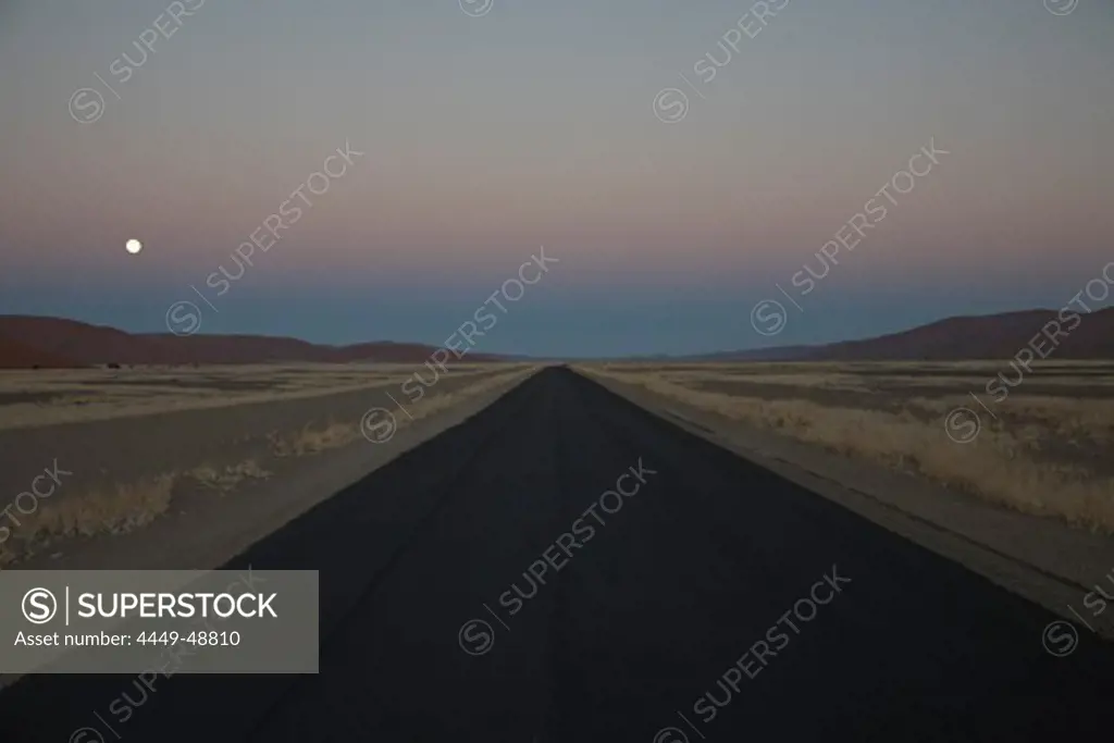 Asphalt road at full moon at Namib Naukluft Park, Sossusvlei, Namibia, Africa