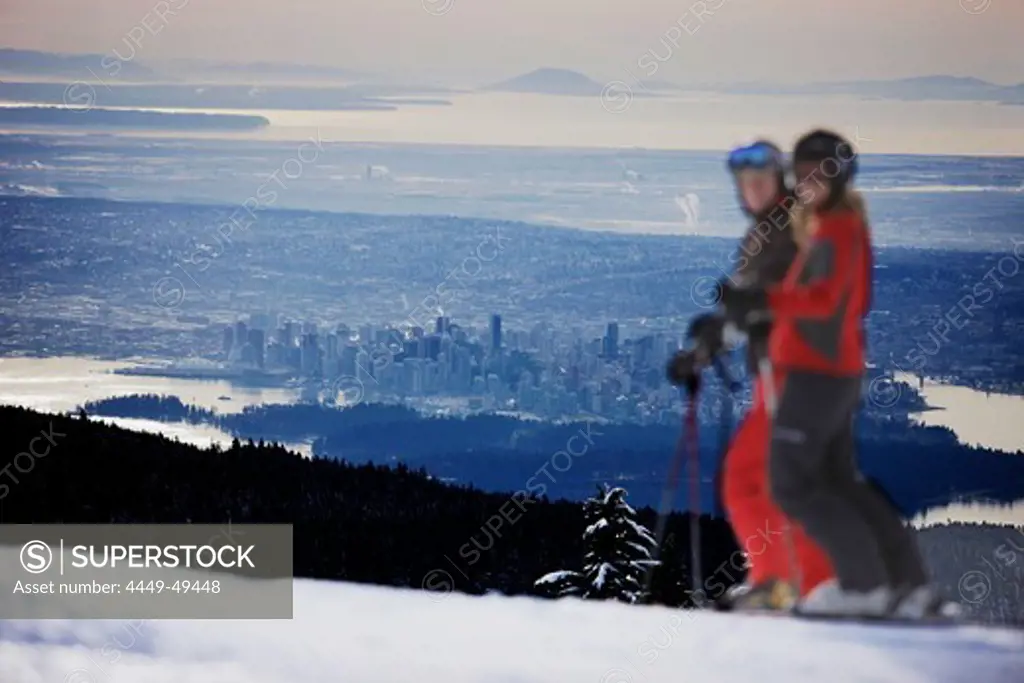 Skiers on slope, Vancouver in background, British Columbia, Canada