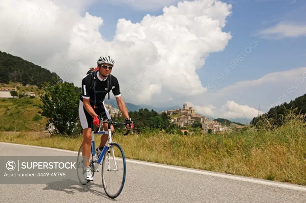 Cyclist in front of Castel del Monte, Monte Prena, Monte Camicia, Gran Sasso National Park, Abruzzi, Italy, Europe
