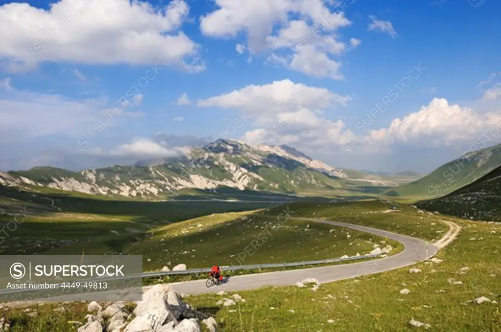 Cyclist on country road at Campo Imperatore, Monte Prena, Monte Camicia, Gran Sasso National Park, Abruzzi, Italy, Europe