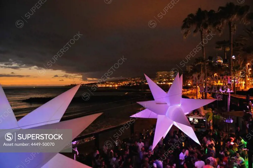 Visitors dance at sundown in the disco at Monkey Beach, Playa de las Americas, South Tenerife, Spain