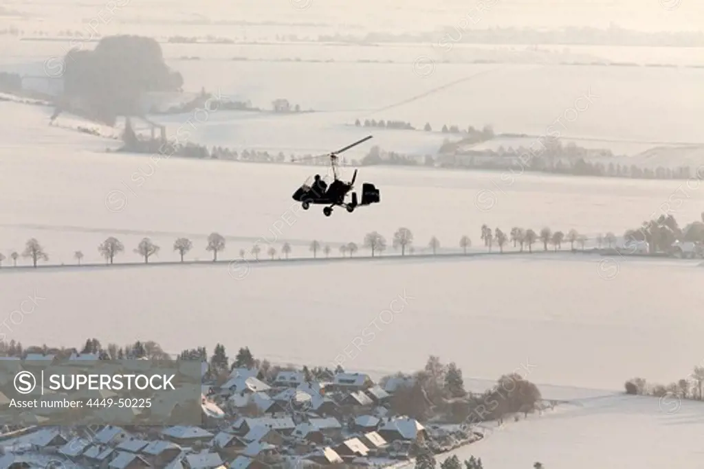 Aerial view of a two-seater autogyro, gyrocopter above a winter landscape, Lower Saxony, Germany