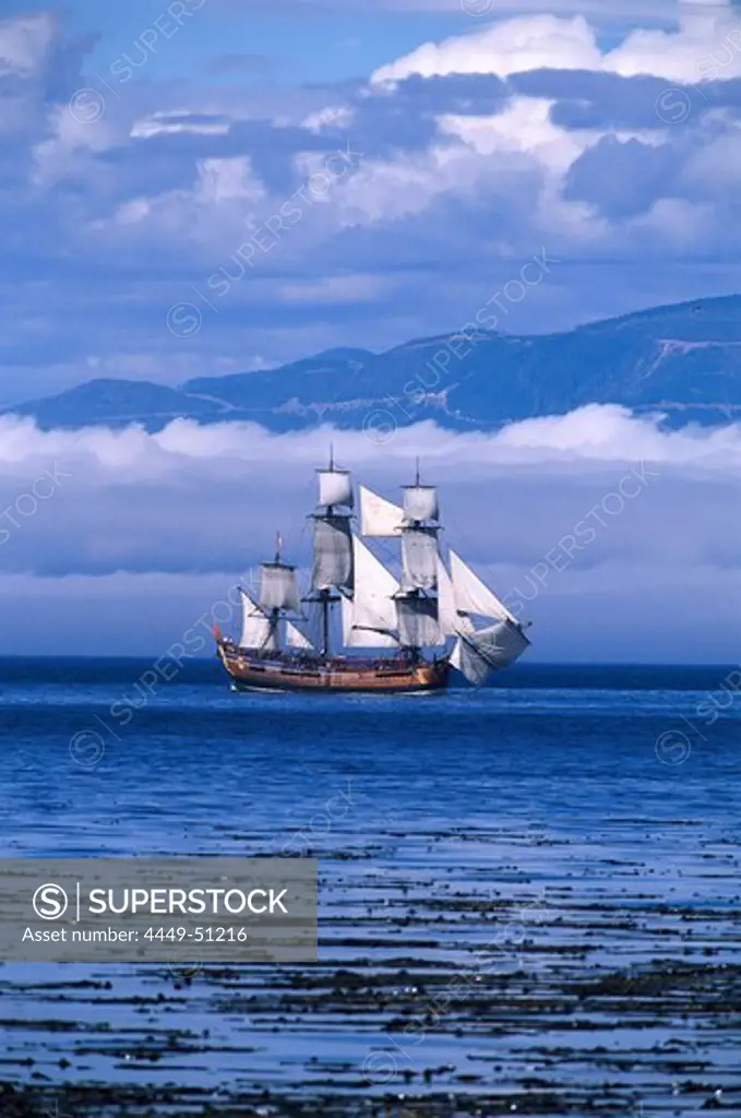 Sailing ship on Juan de Fuca Strait under clouded sky off shore, Washington, USA, America