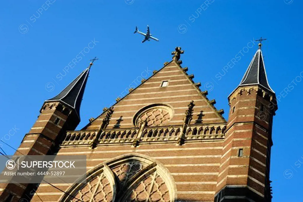 KLM airplane flying over the Nieuwe Kerk church at the Dam square, Amsterdam, the Netherlands, Europe