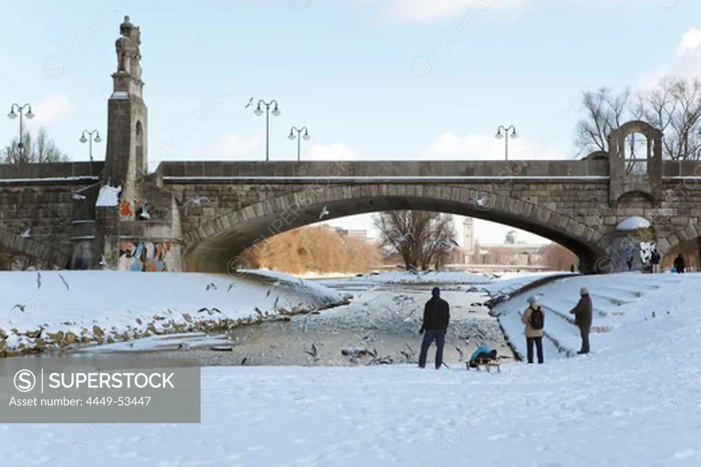 Pedestrians feeding gulls at river Isar near Wittelsbach bridge, Munich, Bavaria, Germany