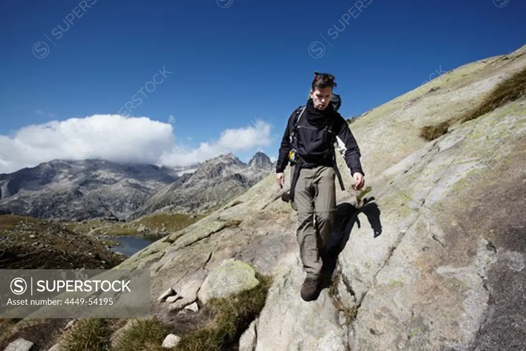 Hiker descending, Serra de Tumeneia, Carros de Foc, Aiguestortes i Estany de Sant Maurici National Park, Catalonia, Spain