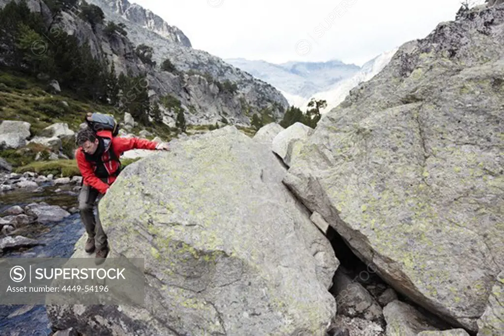 Hiker on rock, Collet de Contraix, Carros de Foc, Aiguestortes i Estany de Sant Maurici National Park, Catalonia, Spain