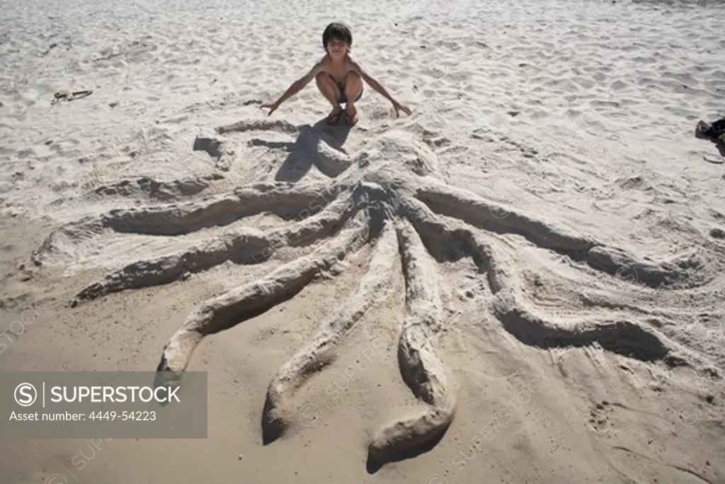 Boy (8 years) near octopus of sand, Haad Thong Reng, Island of Ko Pha Ngan, Surat Thani, Thailand