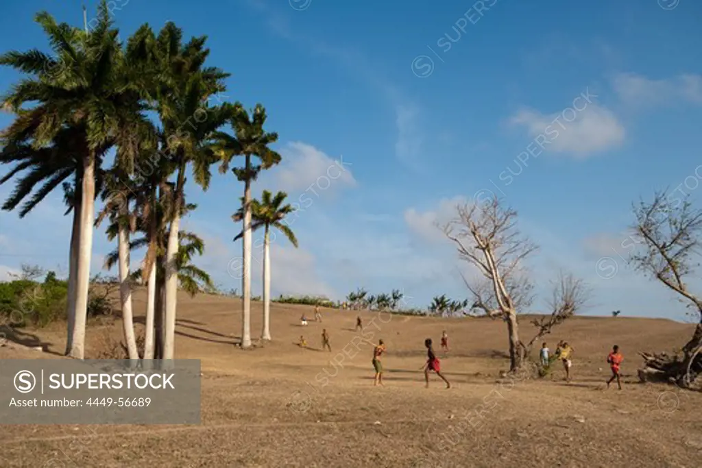 Boys playing baseball on a hillside with palm trees, Pilon, Granma, Cuba
