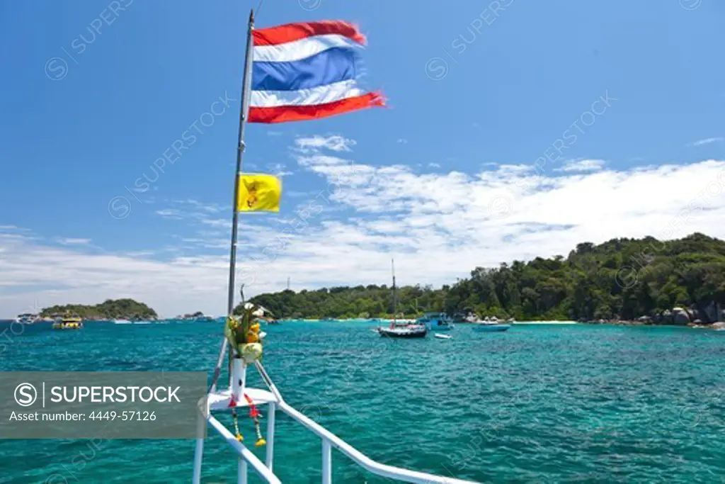 Thai flag in the wind and boats in a bay, Similan Islands, Andaman Sea, Indian Ocean, Khao Lak, Thailand, Asia