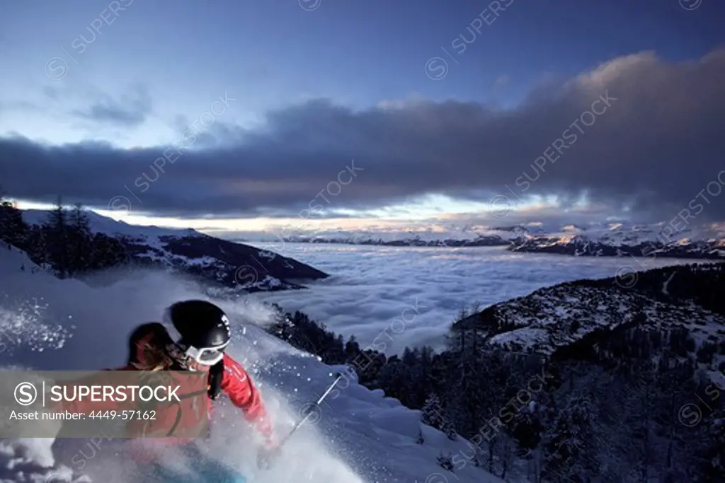 Female skier in deep snow at twilight, Chandolin, Anniviers, Valais, Switzerland