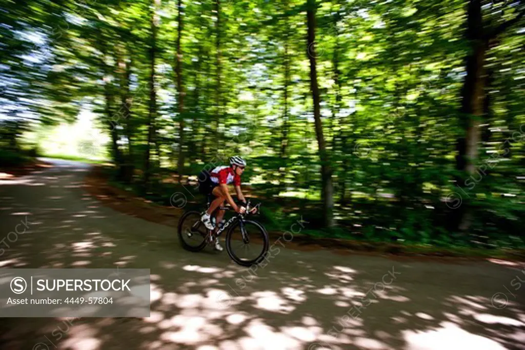 Man road cycling in forest, Bergisches Land, North Rhine-Westphalia, Germany