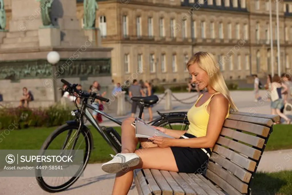 Woman having a break after a bike tour, e-bike, Schlossplatz, New Castle, Stuttgart, Baden-Wurttemberg, Germany