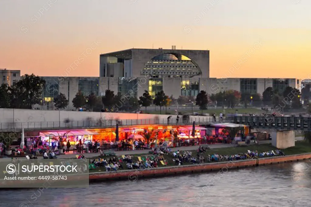 Capital beach cafe at the banks of river Spree, new federal chancellery at dusk, Berlin, Germany, Europe