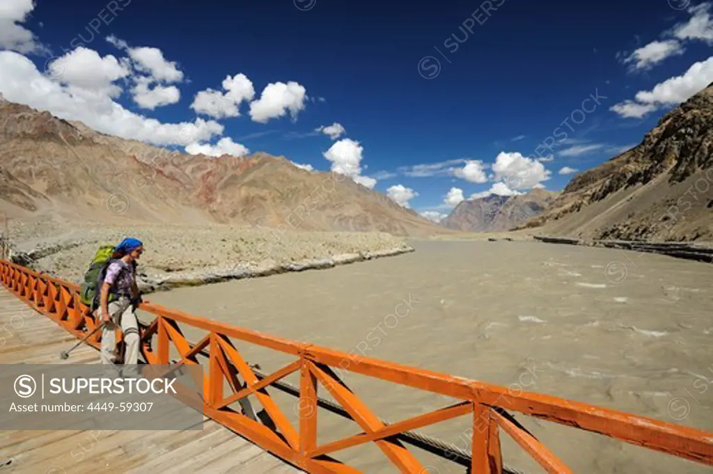 Woman crossing Zanskar river on suspension bridge, Zangla, Zanskar Range Traverse, Zanskar Range, Zanskar, Ladakh, Jammu and Kashmir, India