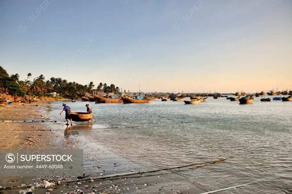 Fishers carry their small boat to the beach, fishing boats, fishing village, South China Sea, Mui Ne, Binh Thuan, Vietnam