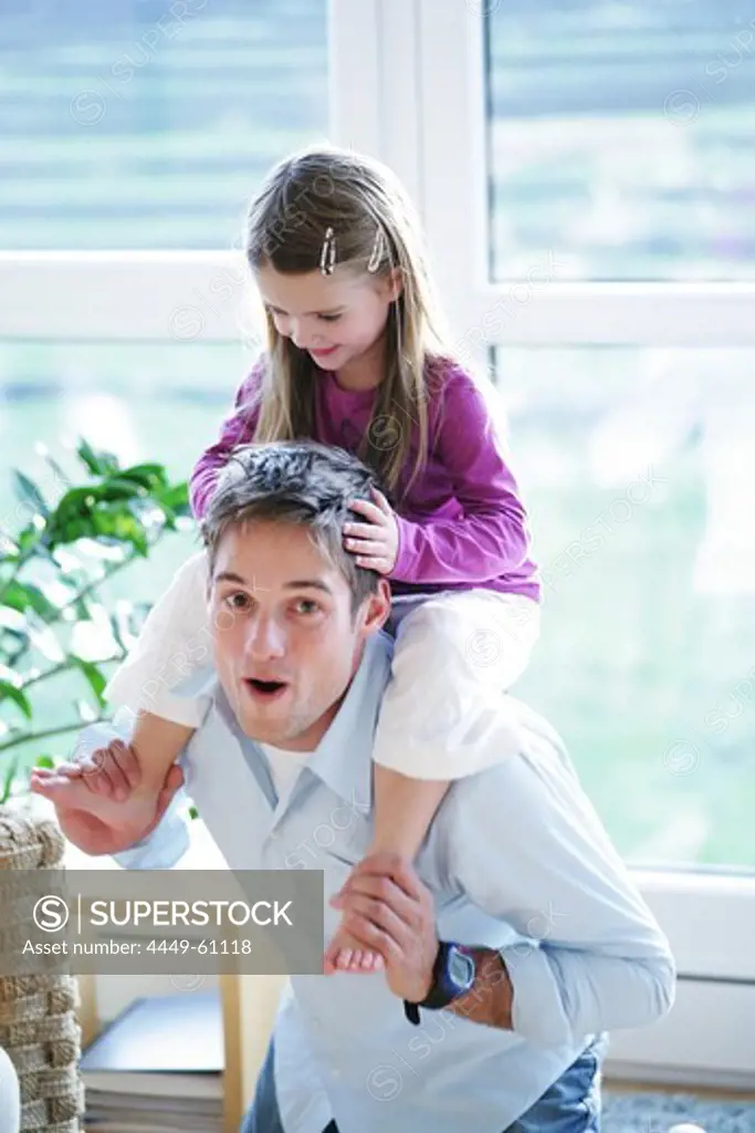 Father giving daughter (3-4 years) piggyback, Munich, Germany