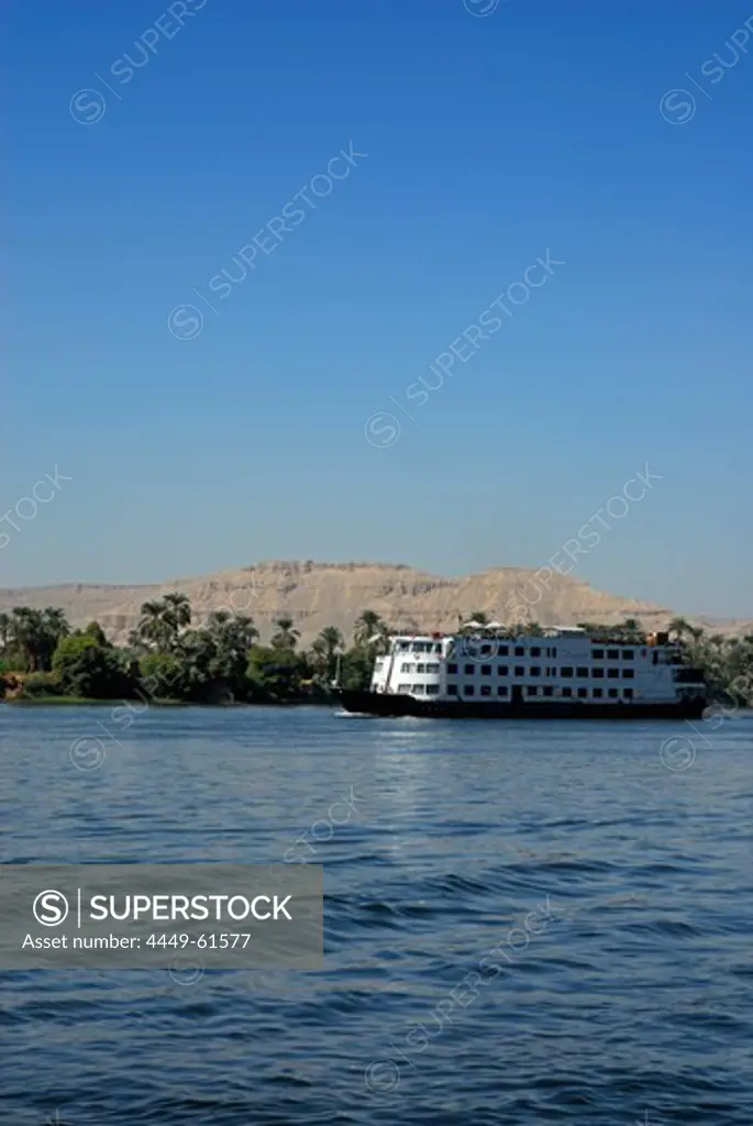 cruise ship on the Nile and palm trees on the western bank, Luxor, Egypt, Africa