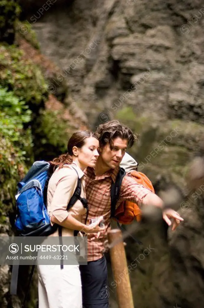 Couple hiking, man showing woman something interesting, Partnachklamm, Garmisch-Partenkirchen, Bavaria, Germany