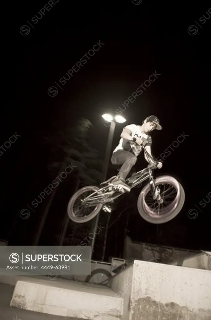 A teenager jumping with his BMX bike at night, Wagram, Austria