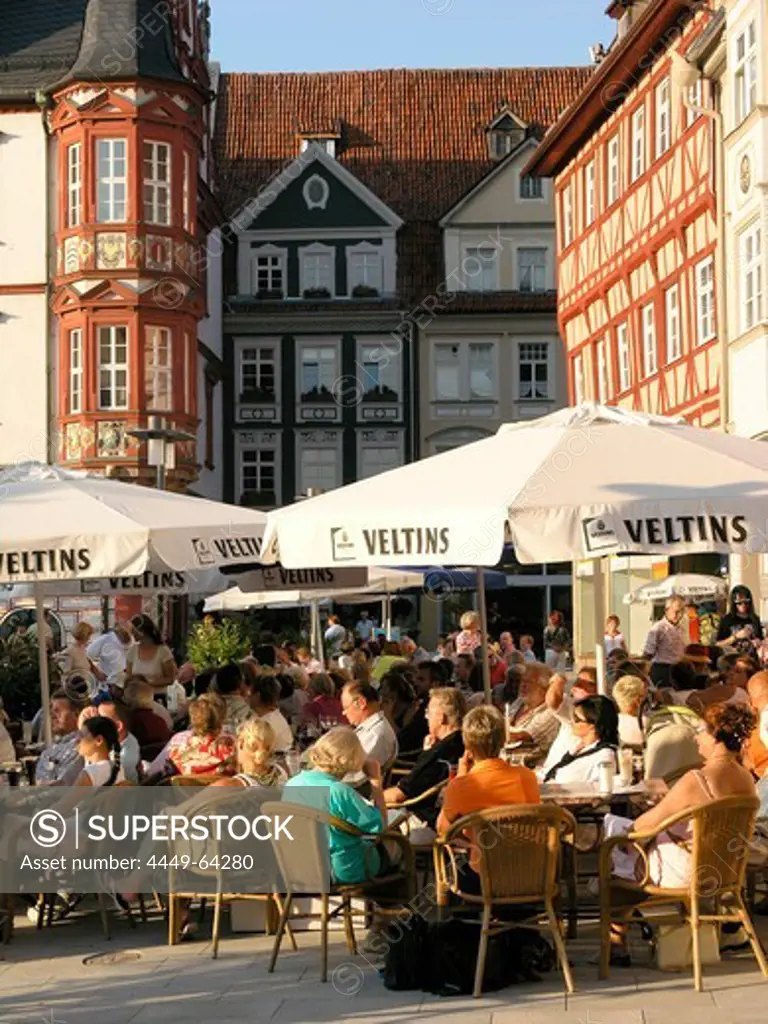 People sitting under sunshades at a sidewalk cafe in the Old Town, Coburg, Franconia, Bavaria, Germany