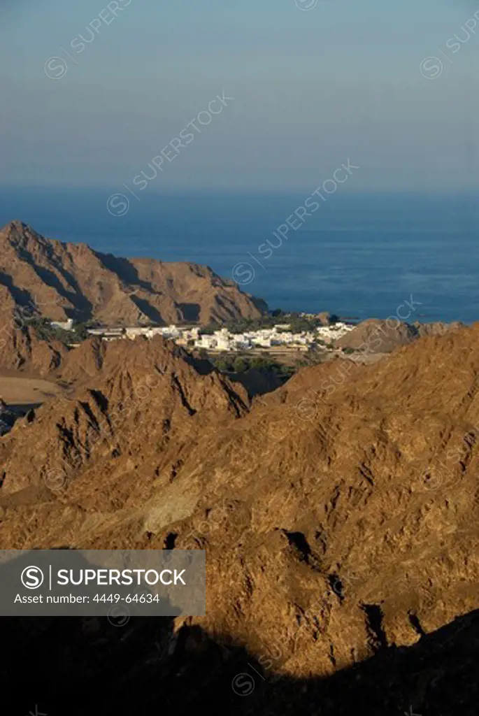 View at houses on rocky coast in the sunlight, Oman, Asia