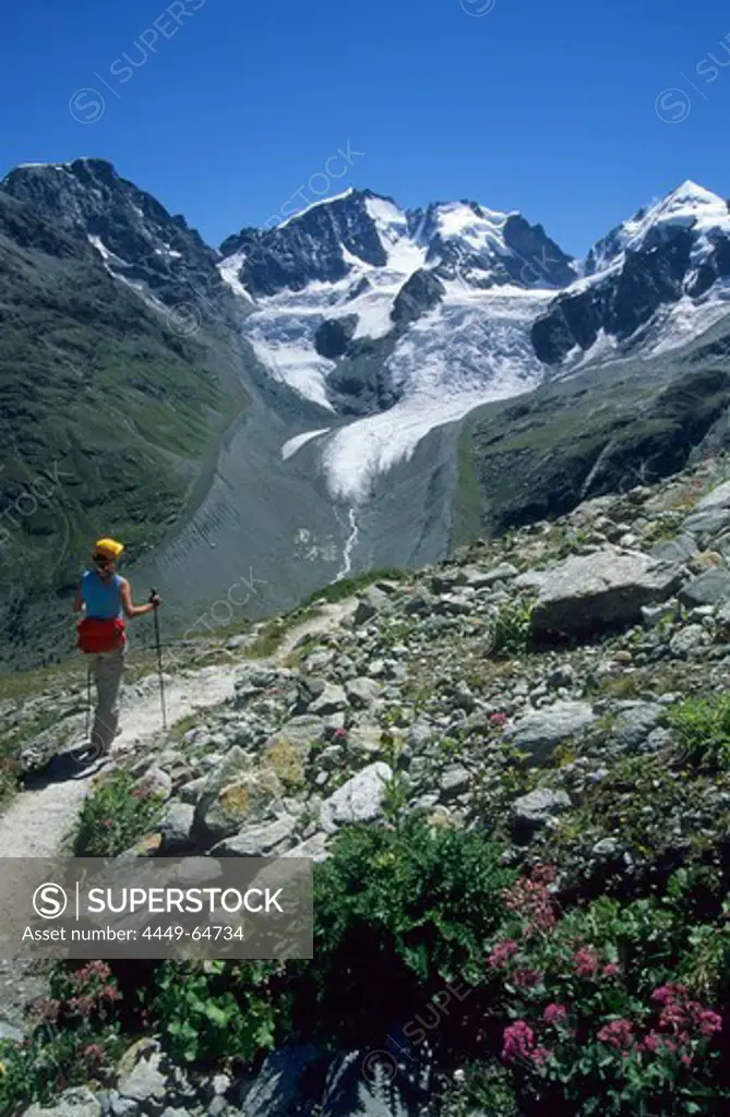 Young woman on hiking trail to alpine hut Coazhuette with view to Piz Morteratsch, Piz Bernina, Piz Scerscen and Piz Roseg, Bernina range, Bernina, Oberengadin, Engadin, Grisons, Switzerland