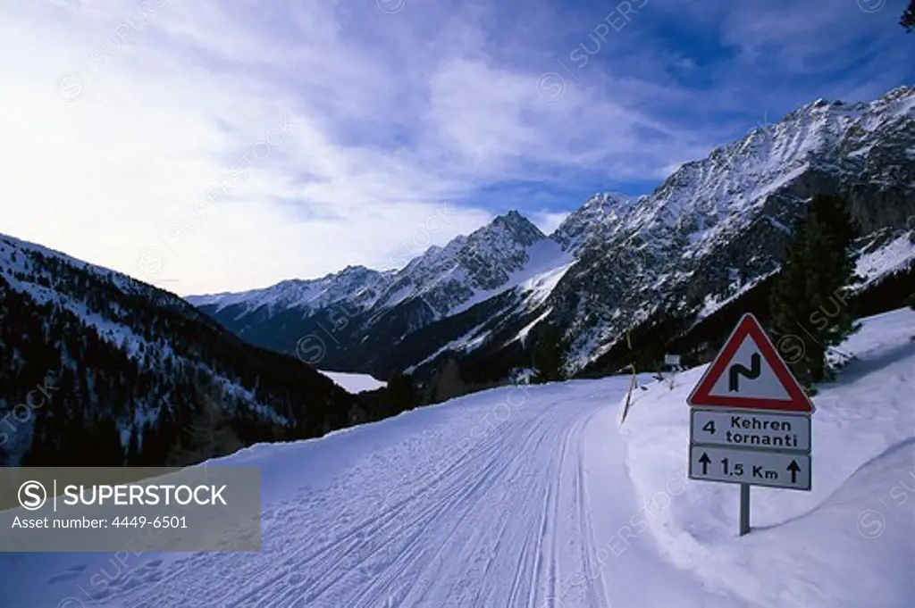 Snowy road and road sign in the mountains, Staller Sattel, Antholz, Val Pusteria, South Tyrol, Italy, Europe