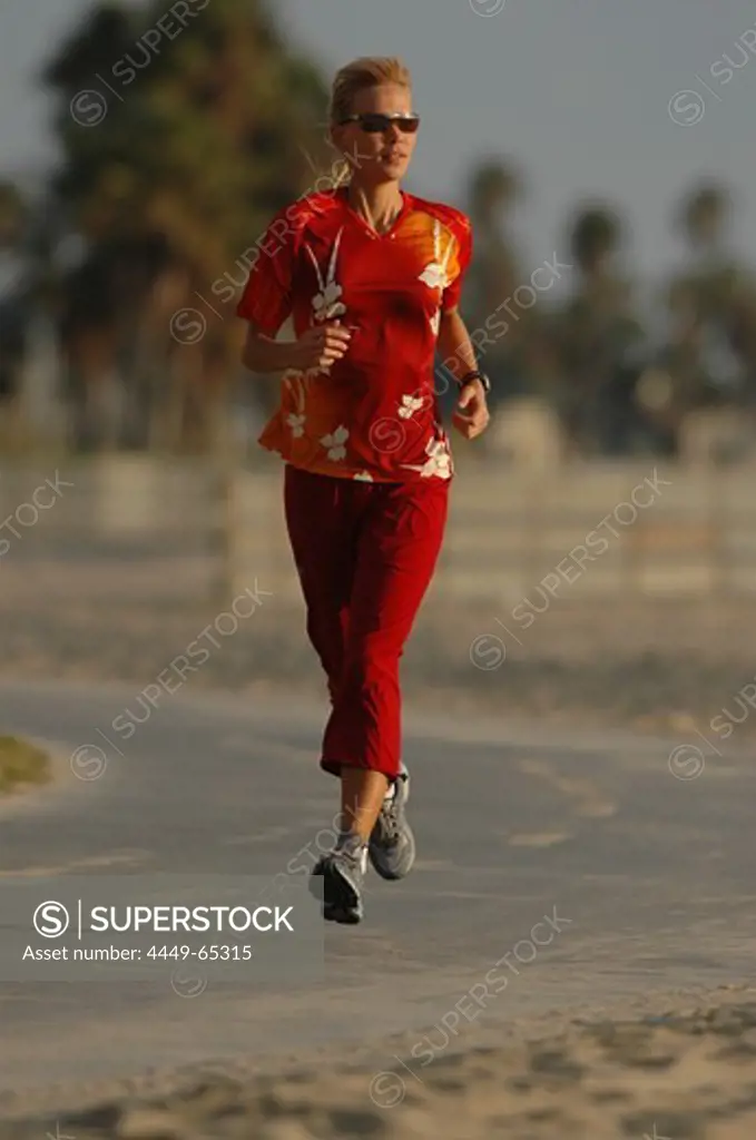 Woman jogging, running along Venice Beach, California, USA