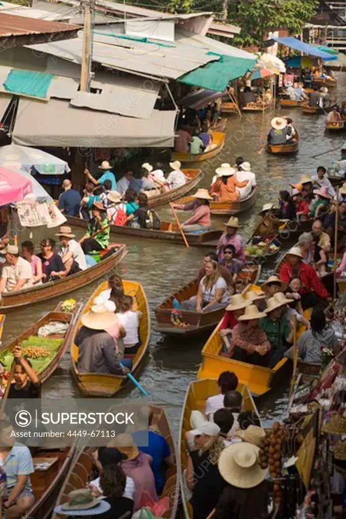 Tourists in a wooden boat visiting the Floating Market, Damnoen Saduak, near Bangkok, Ratchaburi, Thailand