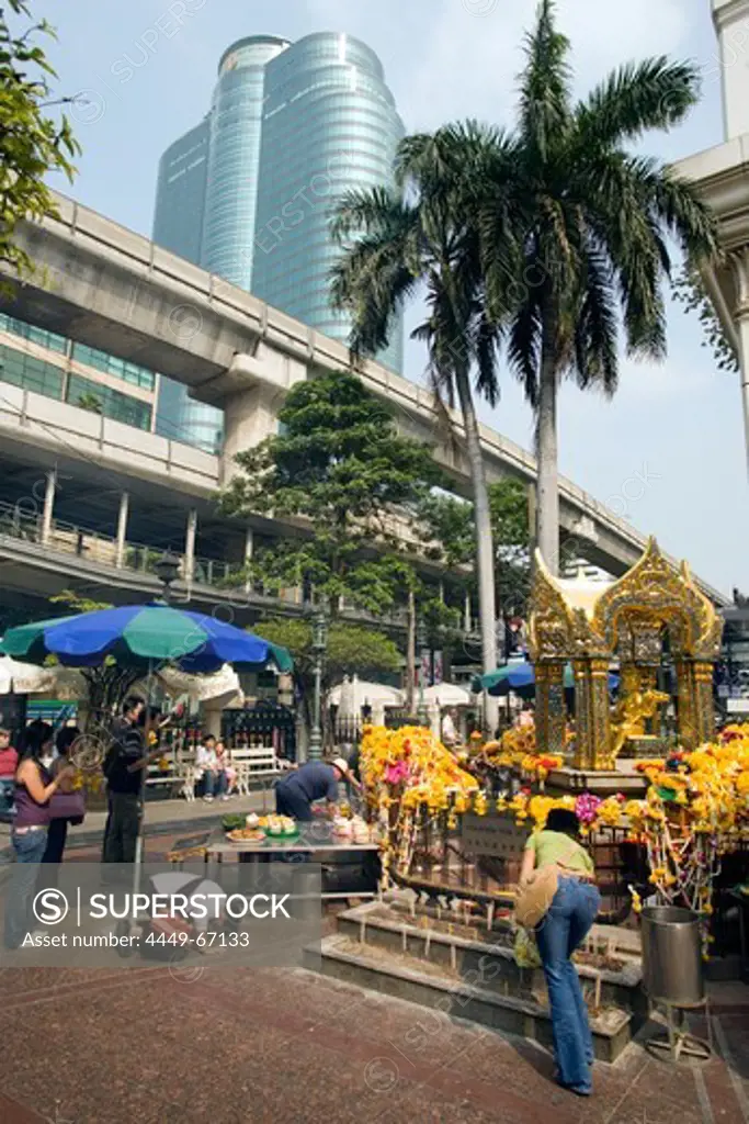 People crouching and praying at Erawan Shrine, Ratchadamri Road near Siam Square, Pathum Wan District, Bangkok, Thailand