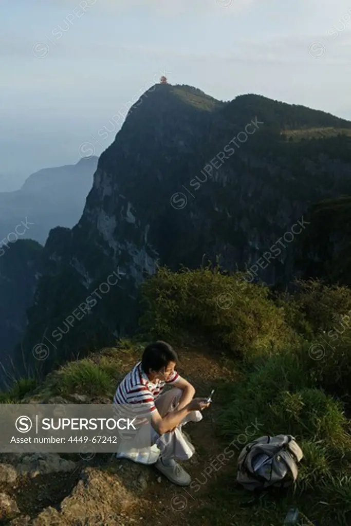 tourist with mobile phone, viewing Wan Fo Ding pagoda, tourist with mobile phone, summit of Emei Shan mountains, China, Asia, World Heritage Site, UNESCO