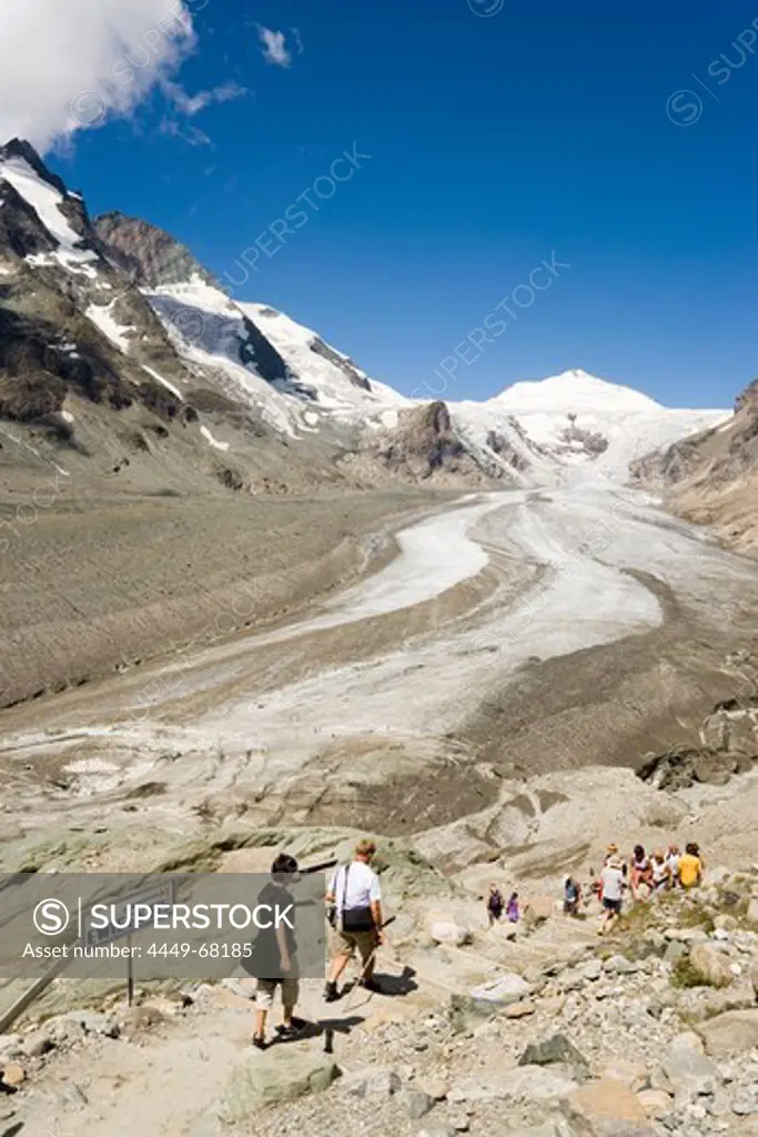 Tourists walking to the Pasterze glacier (the biggest glacier of Austria), Grossglockner (3798 m, highest mountain of Austria) in background, Carinthia, Austria