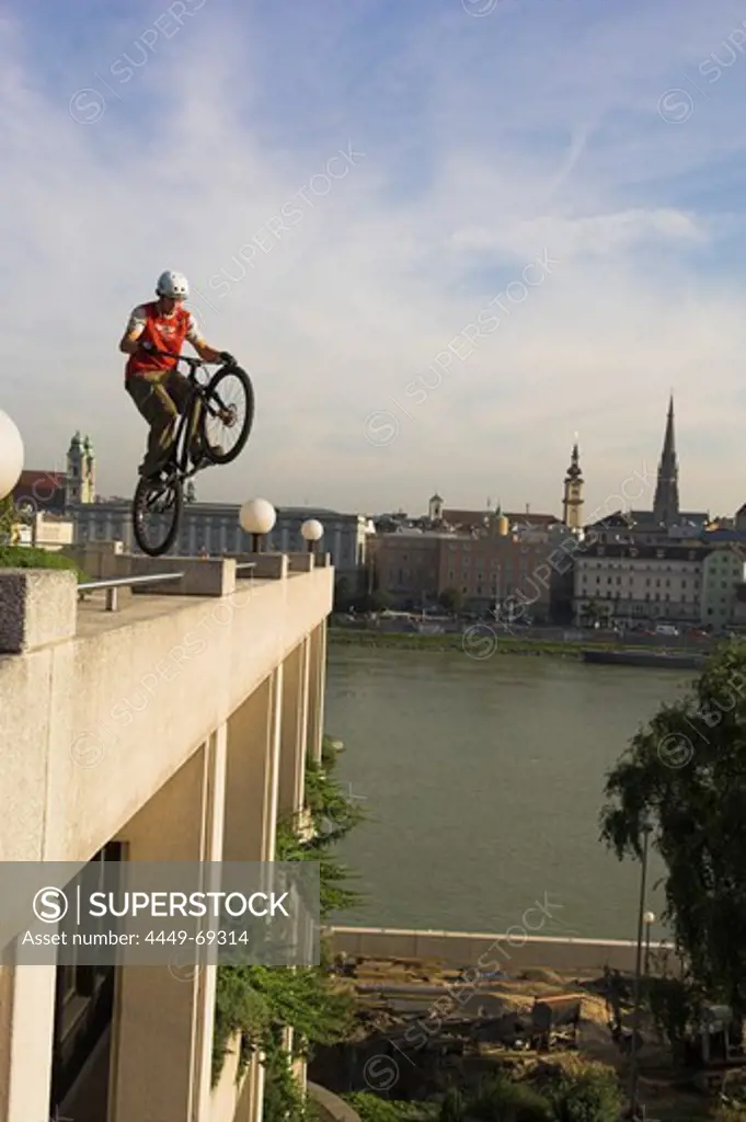 Biker jumping on rear wheel on Town Hall, Linz, Upper Austria