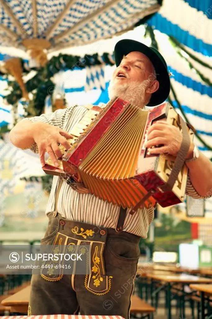 Man wearing bavarian costume playing melodeon