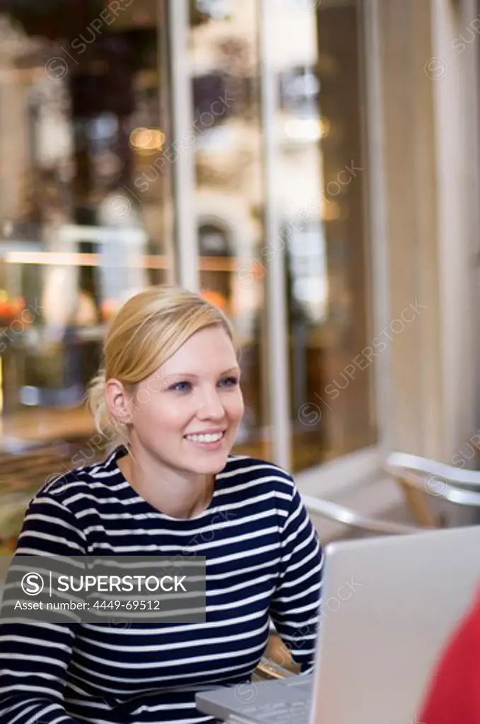 Young woman with laptop in cafe, Luxembourg
