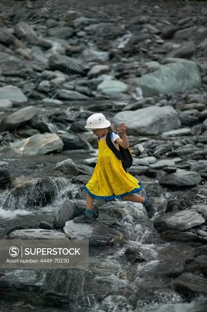 Girl crossing melting water, hiking at Franz Josef Glacier, Westland National Park, Westcoast, South Island, New Zealand