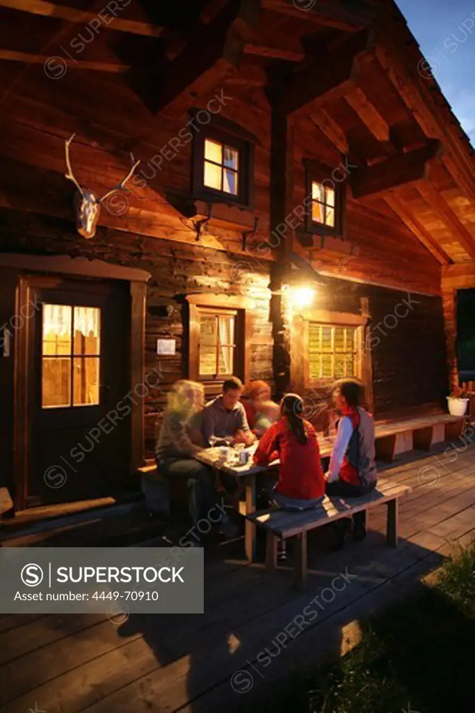 Group of young people in front of an alp lodge, Heiligenblut, Hohe Tauern National Park, Carinthia, Austria