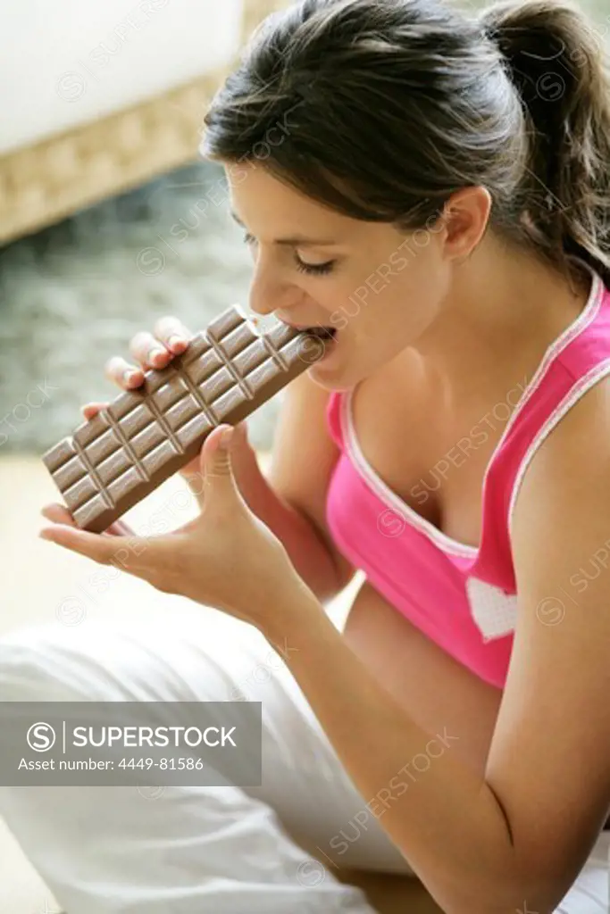 Pregnant woman eating bar of chocolate